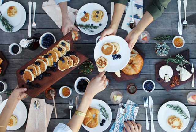 Mehrere Personen essen zusammen und teilen dabei alles auf dem Tisch