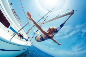 Junge Frau entspannt in einer Hängematte auf einem Boot über dem Wasser