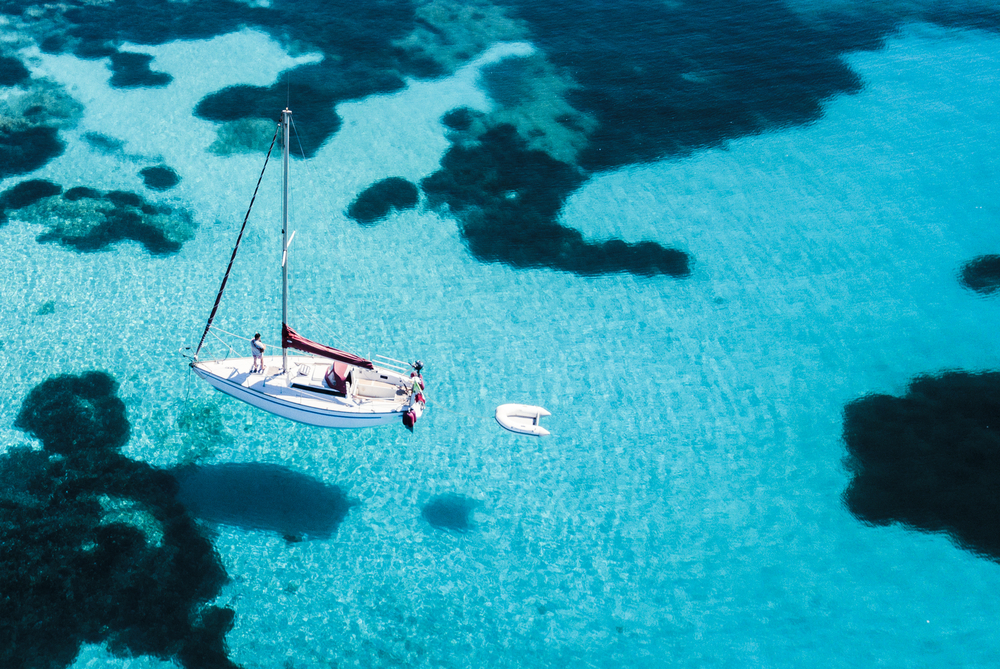 Luftbild eines Segelbootes vor der Insel Mortorio auf Sardinien. Der Strand mit türkisfarbenem und transparentem Meer. Emerald Coast, Sardinien, Italien. 