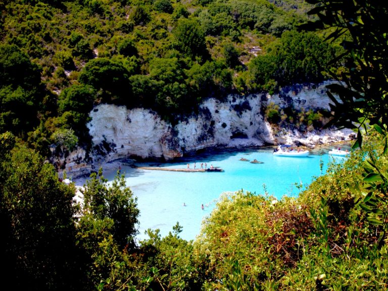 Türkisblaues Wasser in Mitten grüner Natur und weißer Felsen.