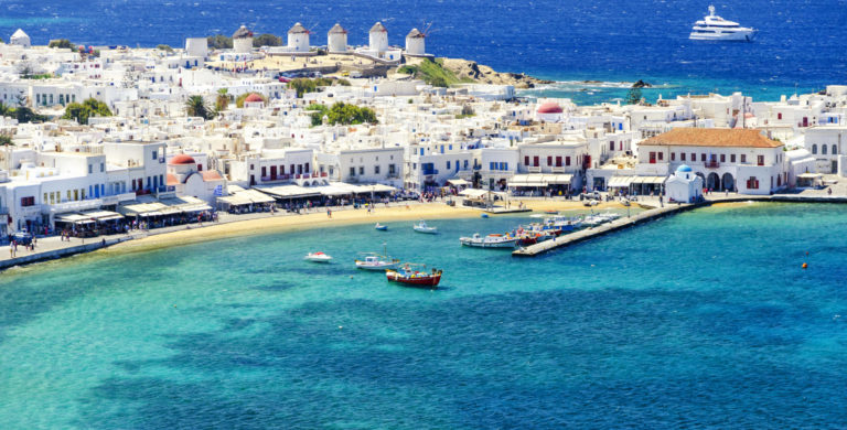 Der Hafen von Mykonos Stadt: türkisblaues Meer und weiße Häuser.