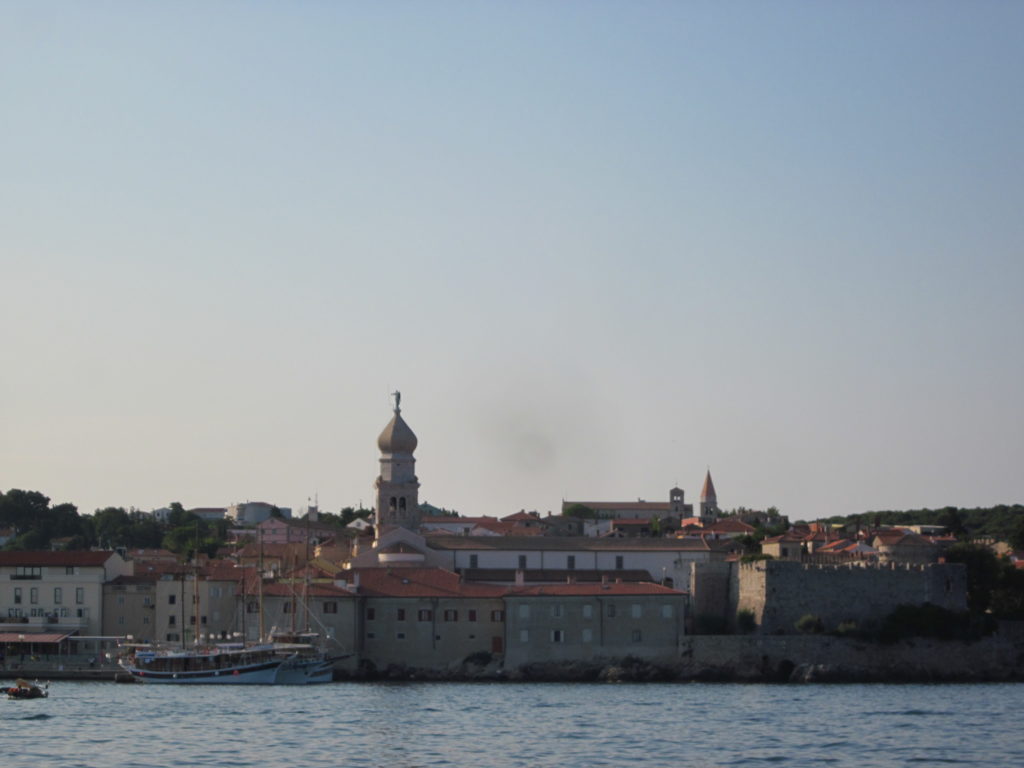 Die morgentliche Ansicht von Krk-Stadt vom Boot aus: alte Hafenstadt am Meer.