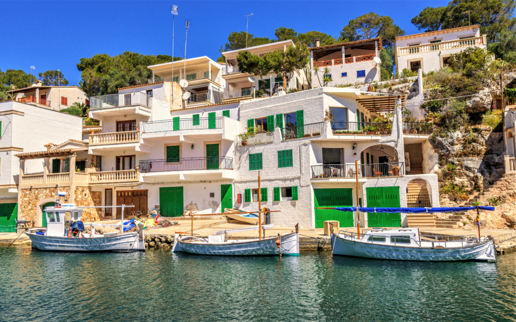 Der Hafen von Cala Figuera: weiß getünchte Fischerhäuser und Fischerboote, die davor ankern.