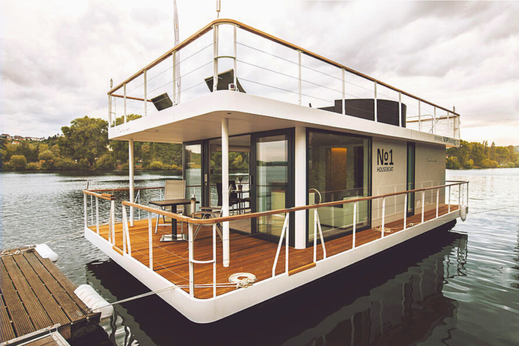 [Bild Modernes Hausboot]
Modernes Hausboot mit Dachterasse, dass auf dem See schwimmt. www.samboat.de