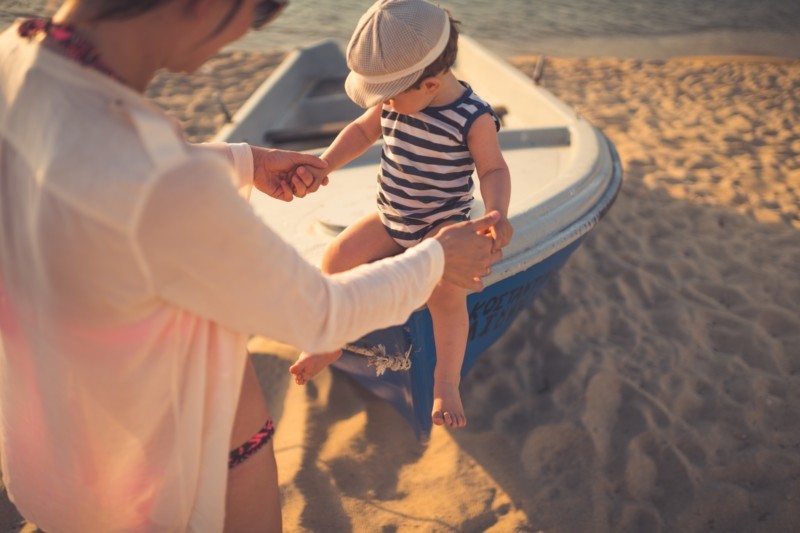 Baby_sitzt_auf_einem_Beiboot_am_Strand