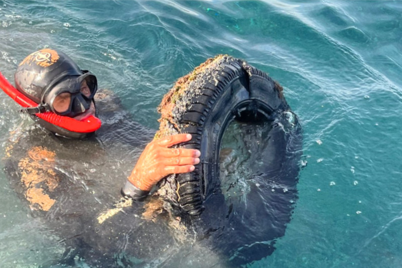 Taucher entfernt einen Reifen aus dem Meer