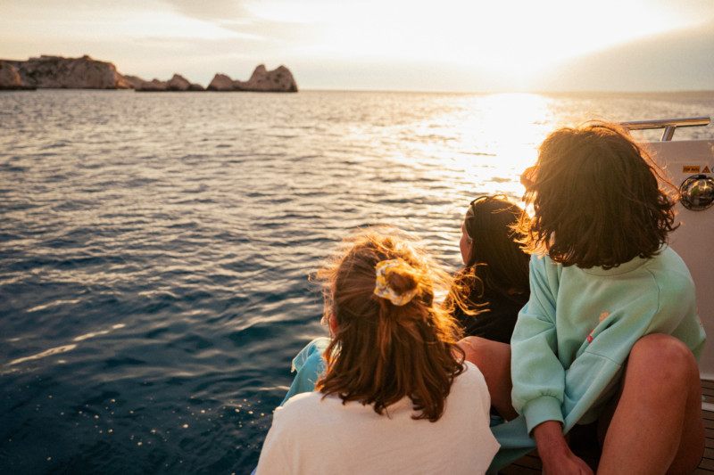 Menschen beobachten den Sonnenuntergang von einem Boot aus