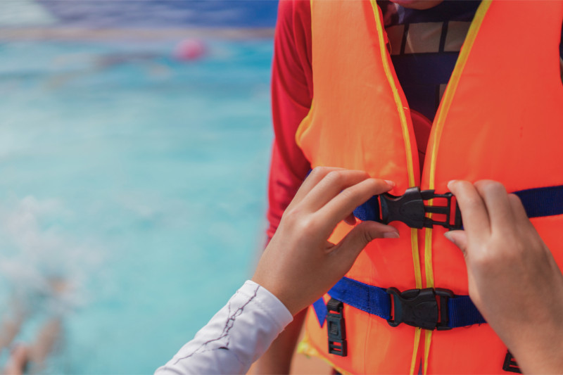 Passagier legt vor einem Bootsausflug eine Rettungsweste an